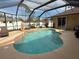 Relaxing kidney-shaped pool with a screened enclosure, perfect for outdoor enjoyment at 3100 Sheboygan Ave, North Port, FL 34286