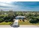 Single-story home with driveway and large backyard, surrounded by lush vegetation at 18565 Edgewater Dr, Port Charlotte, FL 33948