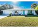 Newly renovated home with teal door and green lawn at 18565 Edgewater Dr, Port Charlotte, FL 33948