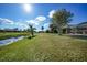 Landscaped backyard features a canal-front view and lush greenery at 221 Sportsman Rd, Rotonda West, FL 33947