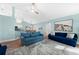 Relaxing living room featuring blue sofas, a large TV, and a ceiling fan at 221 Sportsman Rd, Rotonda West, FL 33947