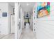 Long hallway with white shiplap walls and coastal artwork at 28492 Royal Palm Dr, Punta Gorda, FL 33982