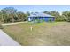 Blue house with white driveway and green lawn at 28492 Royal Palm Dr, Punta Gorda, FL 33982