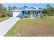 Quaint blue house, metal roof, yellow door, and green lawn at 28492 Royal Palm Dr, Punta Gorda, FL 33982