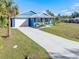 Bright blue house with white trim, metal roof, and yellow door at 28492 Royal Palm Dr, Punta Gorda, FL 33982