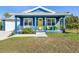 Charming blue house with yellow door and porch swing at 28492 Royal Palm Dr, Punta Gorda, FL 33982