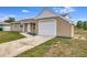 Tan house with white garage door and landscaping at 3324 Avanti Cir, North Port, FL 34287