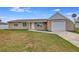 Tan house with white garage door and landscaping at 3324 Avanti Cir, North Port, FL 34287