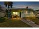 Evening view of charming light green house with covered porch at 3999 Conway Blvd, Port Charlotte, FL 33952