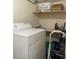 A well-organized laundry room with washer, dryer, and storage shelves at 3999 Conway Blvd, Port Charlotte, FL 33952