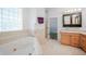 Bathroom with a jetted tub, shower, and light wood cabinets at 4132 Michel Tree St, Port Charlotte, FL 33948