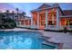 Inviting pool with elegant clubhouse featuring columns and expansive windows at sunset at 4178 Central Sarasota Pkwy # 326, Sarasota, FL 34238