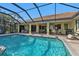 Inviting pool area with screened enclosure, patio furniture, and grilling station at 4315 Cape Haze Dr, Placida, FL 33946