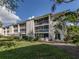 Two-story condo building with balconies, lush landscaping, and ample parking at 437 Cerromar Ln # 312, Venice, FL 34293