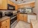 View of kitchen with wood cabinets, granite countertops and stainless steel appliances at 437 Cerromar Ln # 312, Venice, FL 34293