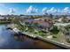 Aerial image of the backyard featuring a boat dock, canal and screen enclosed pool with lush landscaping at 500 Andora Dr, Punta Gorda, FL 33950