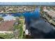 Aerial image showing a dock and boat lift, and a backyard with a screen enclosed pool on a canal at 500 Andora Dr, Punta Gorda, FL 33950