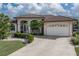 Charming single-story home featuring a tile roof, arched entryway, a manicured lawn and attached garage at 500 Andora Dr, Punta Gorda, FL 33950