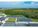 Aerial view of community pickleball courts with colorful surfaces, surrounded by lush greenery at 12470 Wellen Golf St # 203, Venice, FL 34293