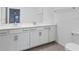 Modern bathroom featuring dual sinks, white cabinets, and quartz countertops at 12470 Wellen Golf St # 203, Venice, FL 34293