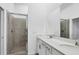 Bathroom featuring dual sinks, white cabinets, a large mirror, and a glass-enclosed shower at 12470 Wellen Golf St # 203, Venice, FL 34293