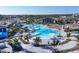 Aerial view of the community pool with tropical landscaping, lounge chairs, and umbrellas at 12470 Wellen Golf St # 203, Venice, FL 34293