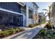 Attractive townhome exterior boasting a screened-in porch, brick walkway, and lush landscaping for a welcoming entrance at 12470 Wellen Golf St # 203, Venice, FL 34293