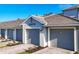 Exterior of townhomes featuring a light gray facade, dark gray roof and matching garage doors at 12470 Wellen Golf St # 203, Venice, FL 34293