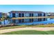 Long view of condos reflected in pond and golf course in background on a sunny day at 12470 Wellen Golf St # 203, Venice, FL 34293