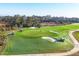 Aerial view of lush, manicured golf course with sand traps and players in golf carts at 12470 Wellen Golf St # 203, Venice, FL 34293