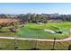 Aerial view of lush, manicured golf course with sand traps, ponds, and players in golf carts at 12470 Wellen Golf St # 203, Venice, FL 34293