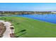 Aerial of the Golf Course Driving Range alongside a Lake, with Golfers in the Background at 12470 Wellen Golf St # 203, Venice, FL 34293