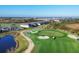 Aerial view of lush, manicured golf course with sand traps, ponds, and nearby homes at 12470 Wellen Golf St # 203, Venice, FL 34293