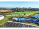 Aerial view of pool featuring lounge chairs and lush landscape in a golf course community at 12470 Wellen Golf St # 203, Venice, FL 34293