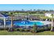 Community pool with lounge chairs and umbrellas overlooks the golf course and manicured landscaping at 12470 Wellen Golf St # 203, Venice, FL 34293