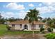 Single-story home with a brown roof, palm tree, and landscaped yard at 1713 Belvidere Rd, Englewood, FL 34223