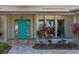 Welcoming teal front door and landscaped entryway with a brick-paved walkway at 2199 El Cerito Ct, Punta Gorda, FL 33950