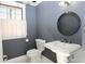 Charming powder room with pedestal sink, round mirror, and stylish gray walls at 225 Bangsberg Se Rd, Port Charlotte, FL 33952