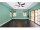 Bedroom features tile floors, a tray ceiling with fan, slider doors, and two windows at 225 Bangsberg Se Rd, Port Charlotte, FL 33952