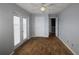 Bedroom with hardwood floors, ceiling fan, and French doors leading to a balcony at 225 Bangsberg Se Rd, Port Charlotte, FL 33952