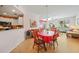 Bright dining room with wood flooring, red table, and kitchen view at 255 W End Dr # 2412, Punta Gorda, FL 33950