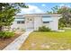 Cute white brick ranch home with light blue awnings and a well-maintained lawn at 330 45Th S St, St Petersburg, FL 33711