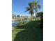 Spacious backyard with grassy lawn, palm trees, and waterfront canal view at 4156 Bardot Rd, Port Charlotte, FL 33953