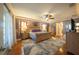 Main bedroom with king-size bed, hardwood floors, and ceiling fan at 7529 Coral Tree, Punta Gorda, FL 33955