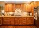 View of kitchen with wood cabinets, granite countertops, and cooktop at 7529 Coral Tree, Punta Gorda, FL 33955