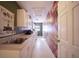 Bright laundry room with white cabinets and floral wall mural at 7529 Coral Tree, Punta Gorda, FL 33955