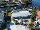 Home with metal roof, driveway, lush landscaping, backyard pool, and canal in the backyard at 193 N Waterway Nw Dr, Port Charlotte, FL 33952