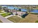 Waterfront home with a well-manicured lawn, mature palm trees, and a screened lanai overlooking the scenic water view at 2321 Sofia Ln, Punta Gorda, FL 33983