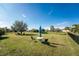 Large backyard with lush grass, a patio set, and a large tree at 386 Royal Poinciana, Punta Gorda, FL 33955