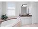 Relaxing bathroom with a large soaking tub, granite countertop, and a window at 386 Royal Poinciana, Punta Gorda, FL 33955